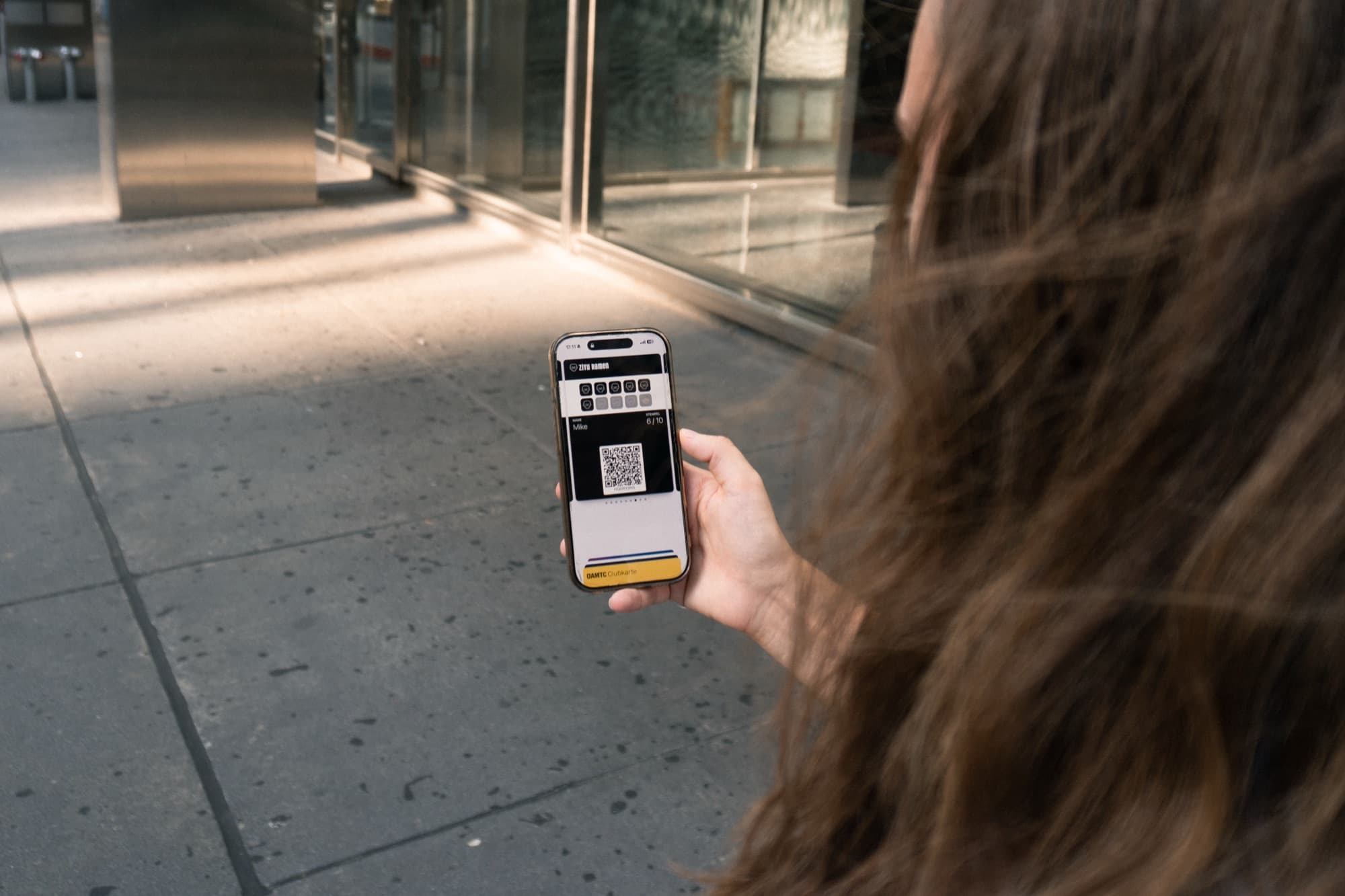 Eine Kundin ruft ihre digitale Stampzino-Stempelkarte auf dem Smartphone auf